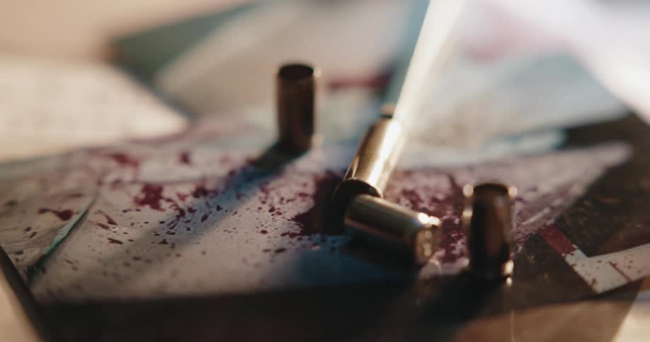 Shell casings lie on blood splattered cracked tiles