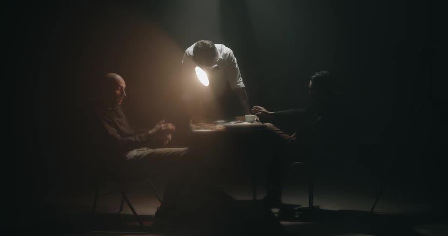 Detective shines a bright light over a suspect inside an interrogation room