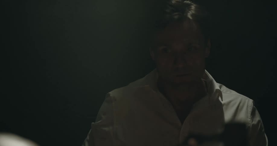 A man looks on in the dark room
