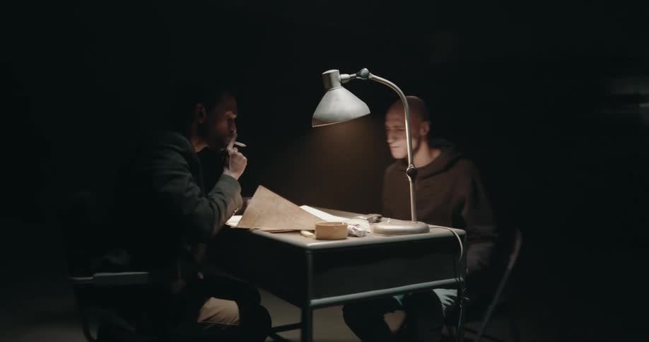 Detective having an argument with a suspect in an interrogation room