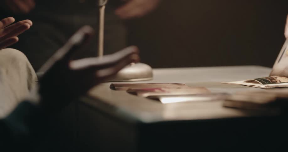 A detective lays down photos to show a suspect during an interrogation