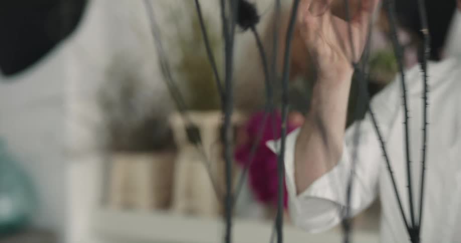 A man talks while making a flower arrangement in a professional store