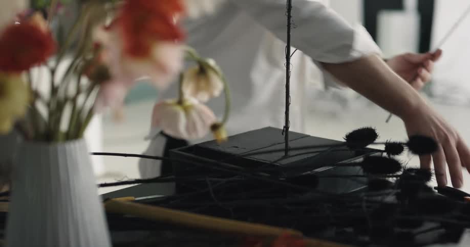 A florist putting together a flower arrangement