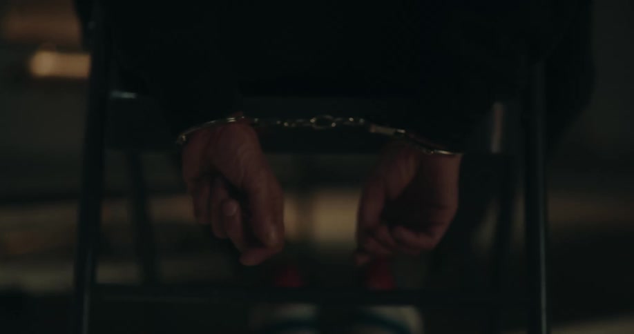 A person is handcuffed by the table