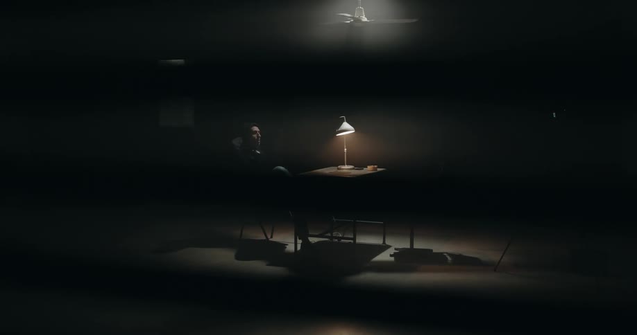 A man is sitting at a table in a room by himself