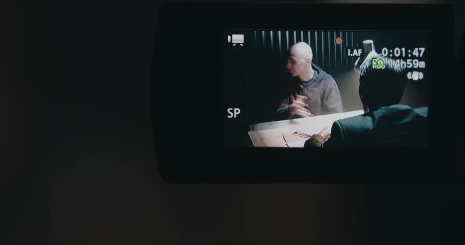 Close up of the viewer of a vcr recording of a man being interrogated
