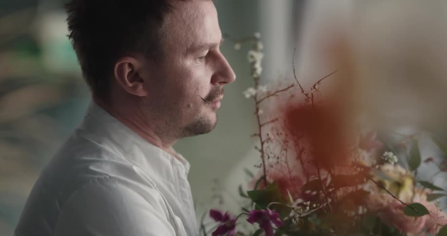 An employee in a store is arranging a flower bouquet