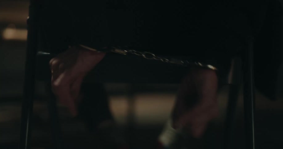 A man is struggling to get handcuffs off