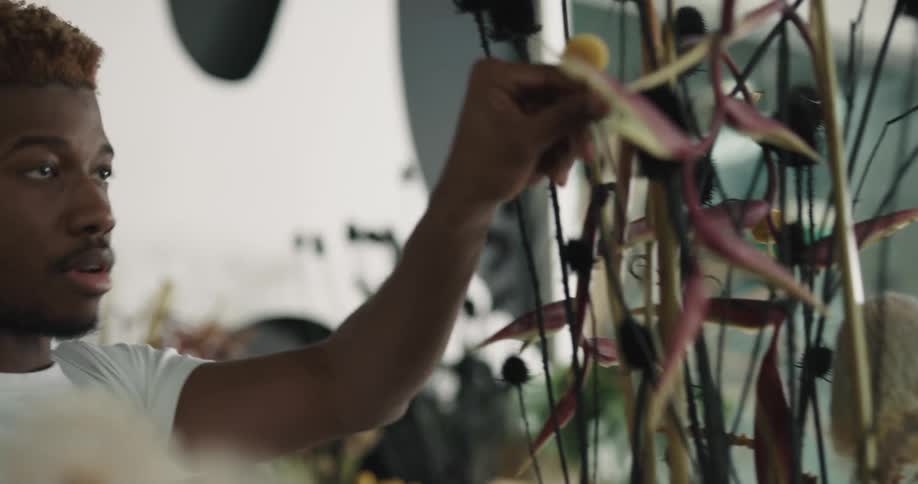 A man is arranging flowers in a bouquet