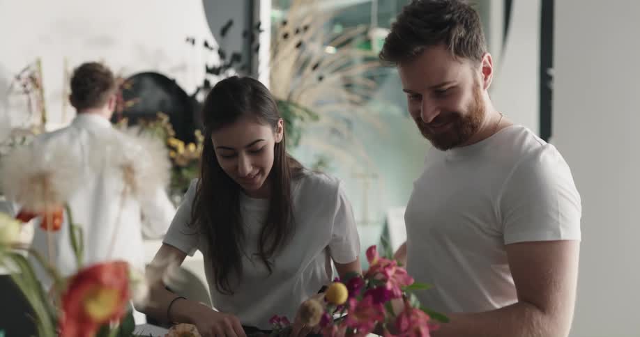 People are holding flower bouquets in a shop