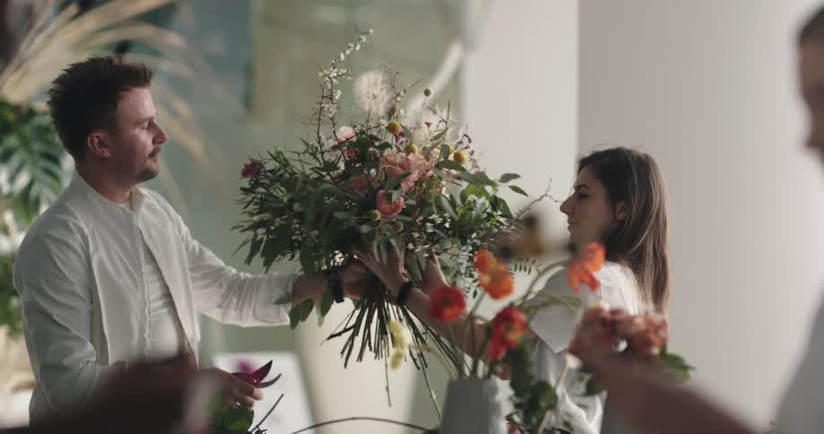 People are looking at flowers in a shop