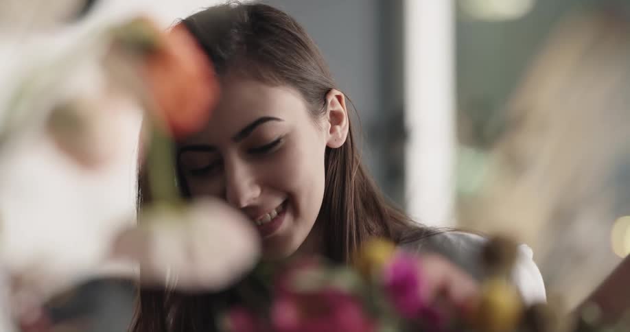 A woman is talking and looking at flowers