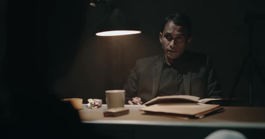A man is smoking in the interrogation room