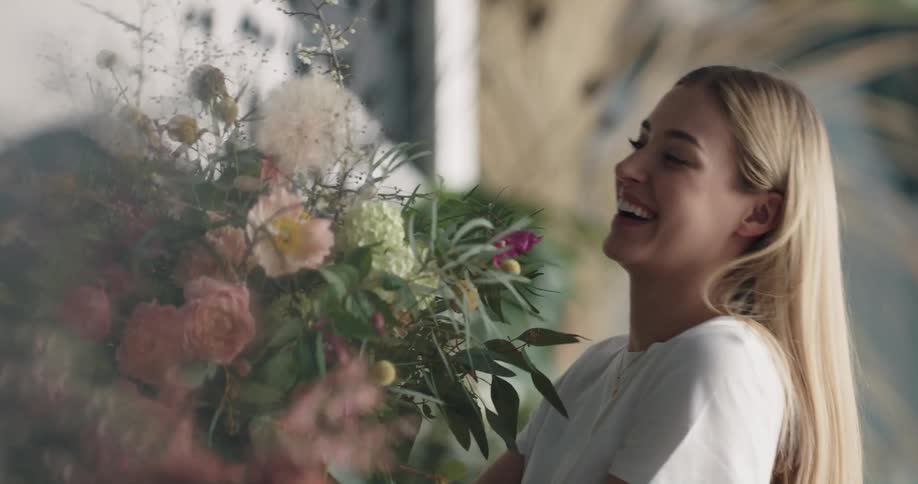 A woman is holding a bouquet of flowers