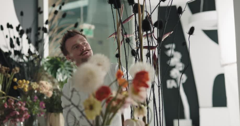 A man is arranging flowers in the shop