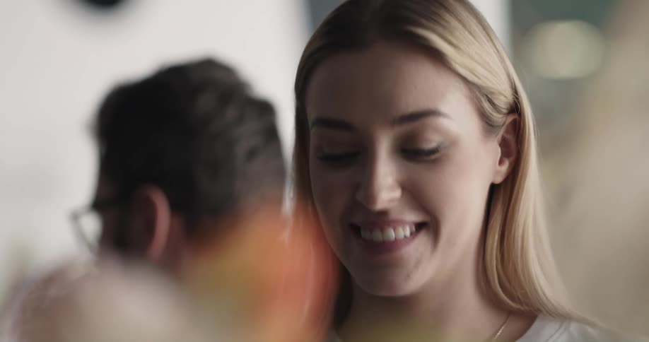 A florist smells a bouquet before handing it to a customer