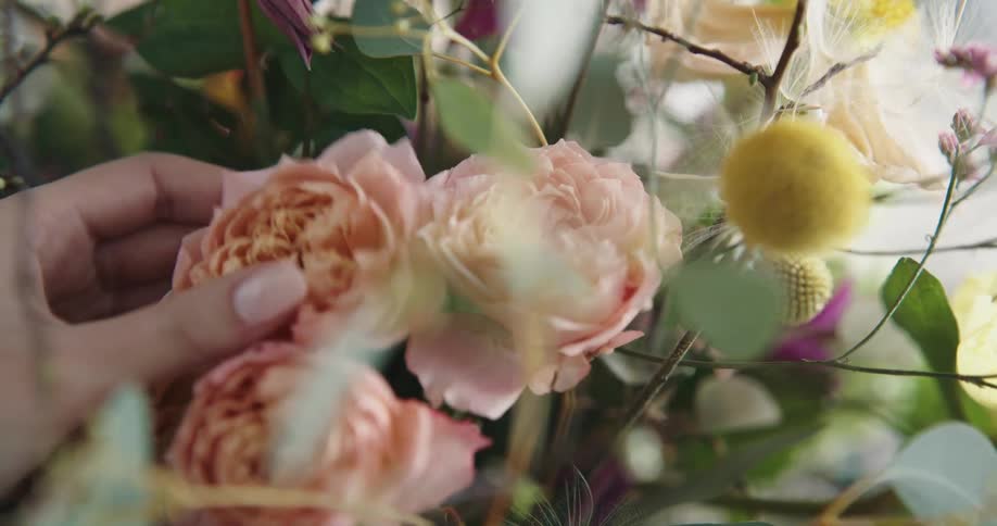 A person is rearranging flowers in a bouquet