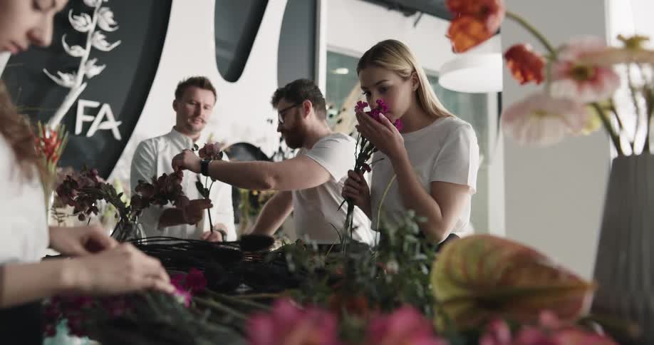 A group of people is arranging flowers on a table