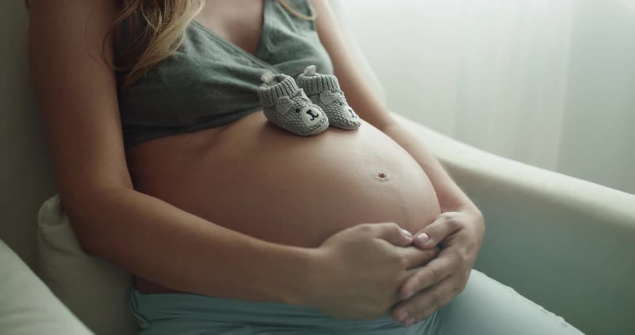 A pregnant woman is sitting in a rocking chair