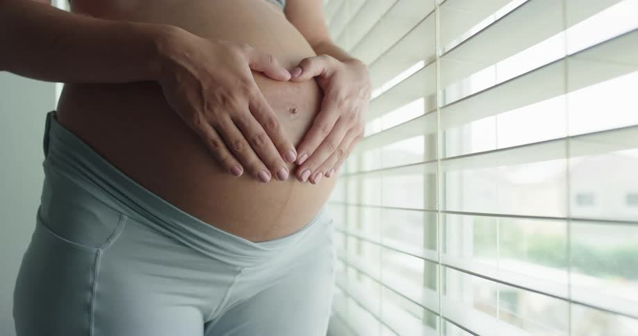 Pregnant woman is touching her belly