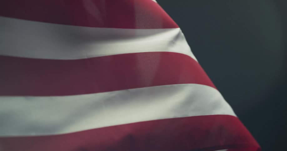 An american flag waves in the wind in a dark place