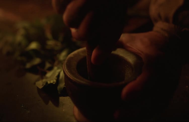 Person uses mortal and pestle on white material