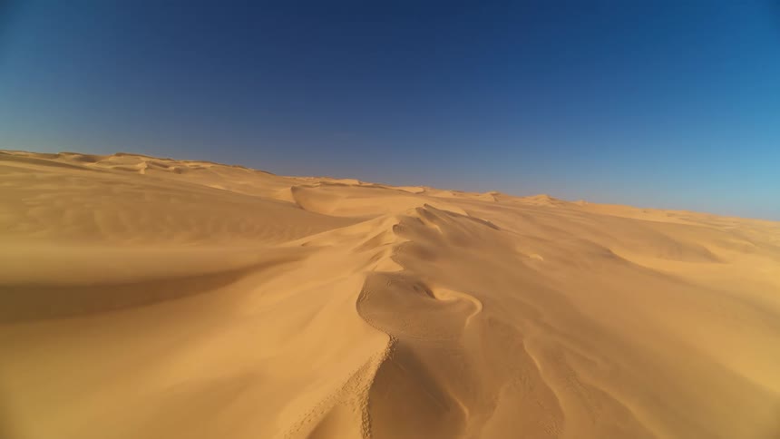 The vast Namib Desert with wind blowing the sand dunes