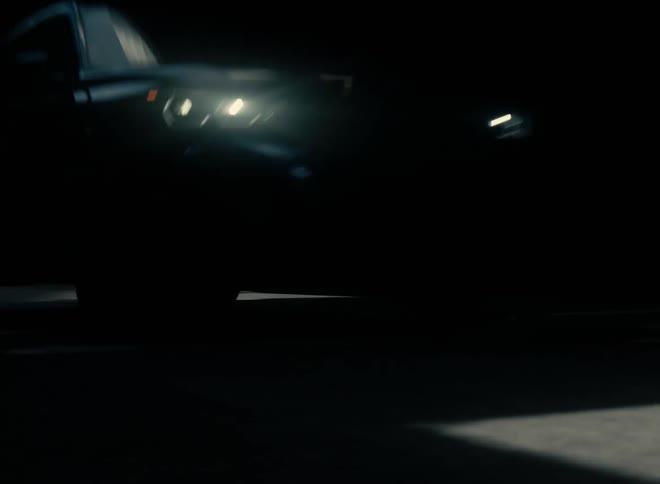 A car is driving on a road during the night time