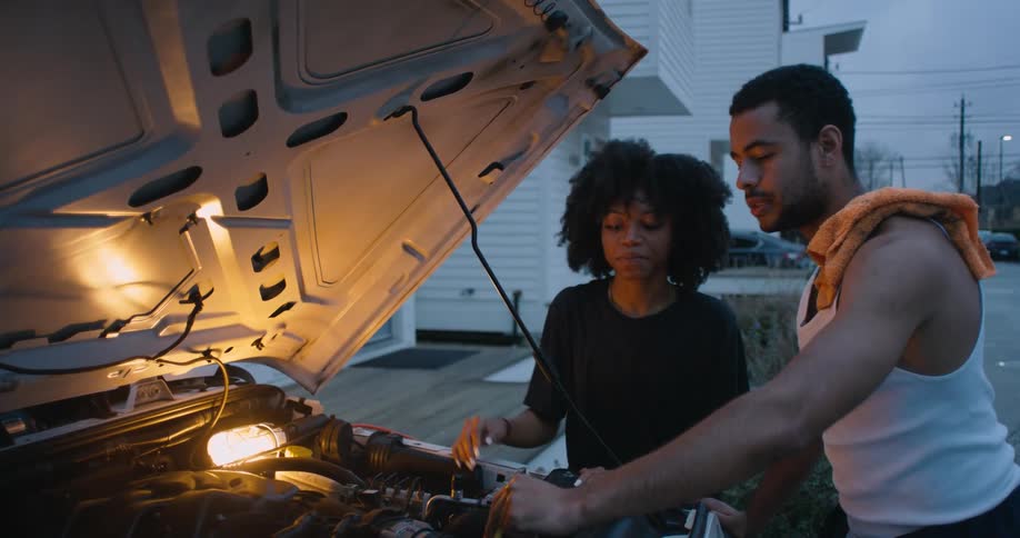 Young woman and man are fixing a vehicle