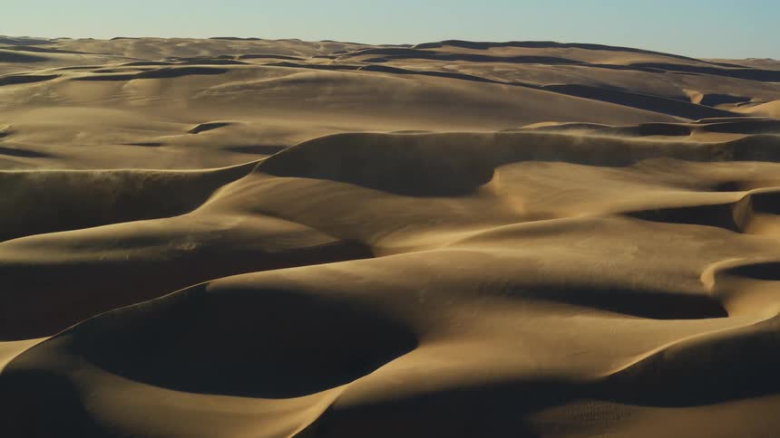 Aerial view of sand dunes blowing in the wind in Namibia