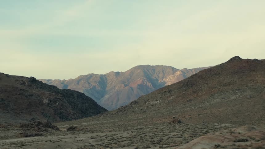 The sun is setting above the mountainous landscape