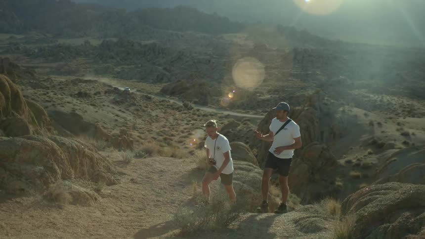 Two people are hiking in the wilderness at dusk