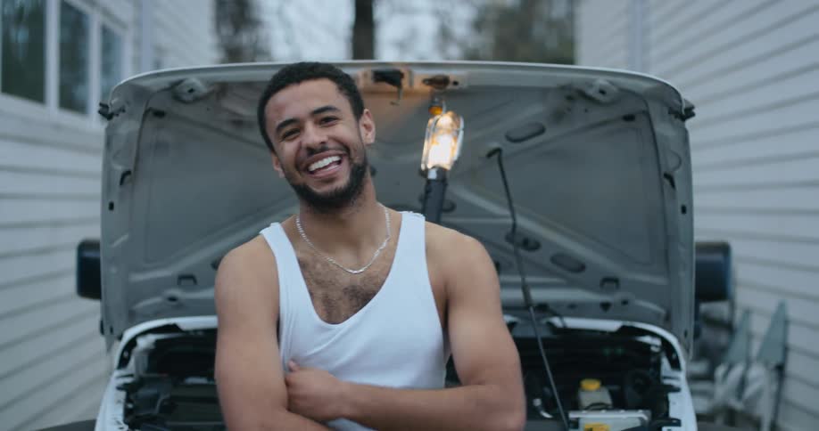 Young man and standing in front of a vehicle