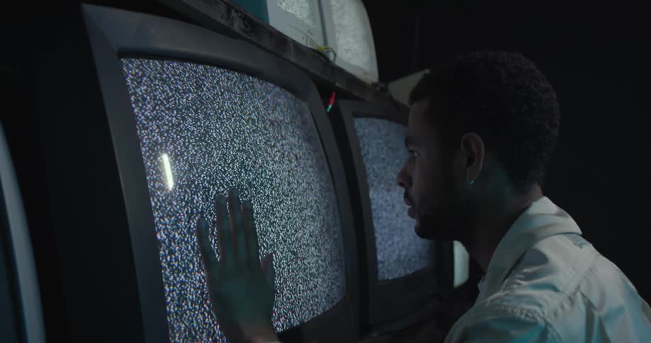 A man is touching a television in a room