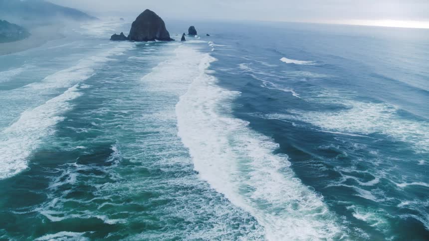 Interesting camera work flying over the Pacific Ocean with rock formations jutting out of the water