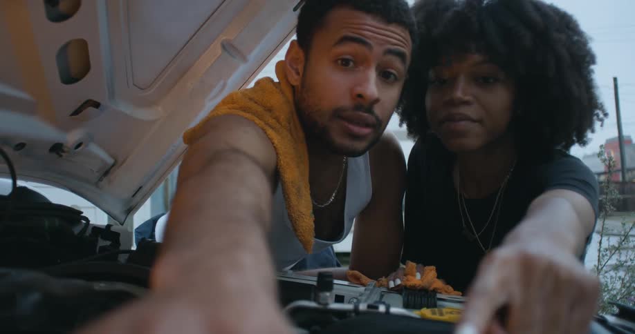 Woman and man are fixing a car