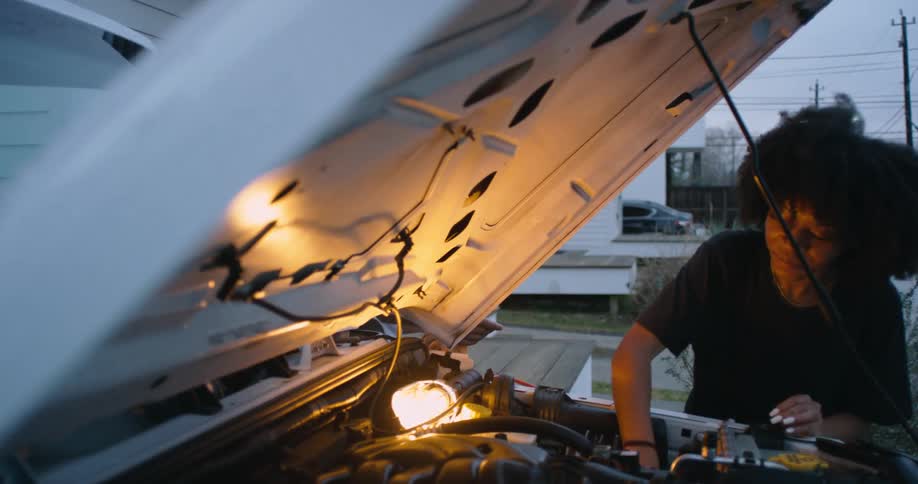 Man is talking to a woman while she is fixing a car