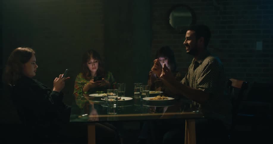 Friends are eating together and on there phone