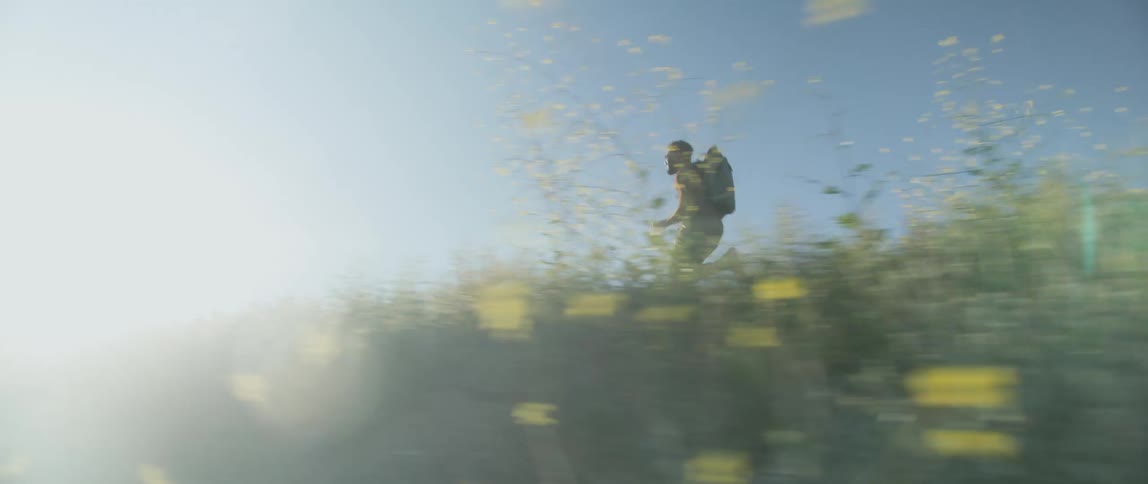 Man is running in a field of weeds in the spring time