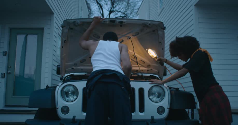 Man and woman are fixing a car outdoors in spring