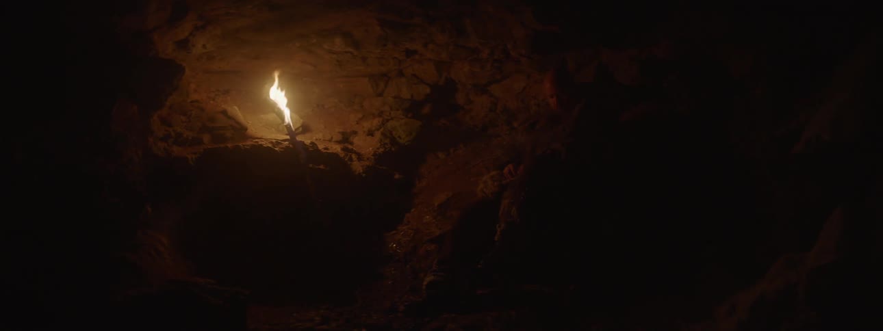 A flame burning in a dark cave