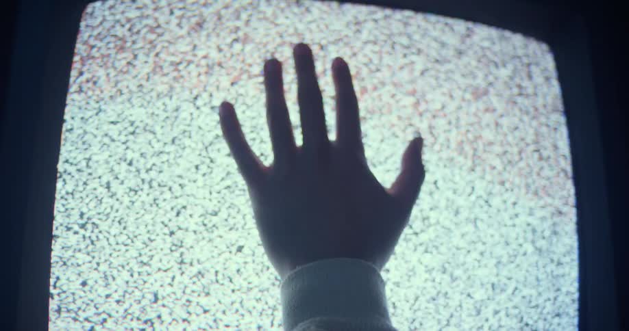 A man is touching a television screen with his hand