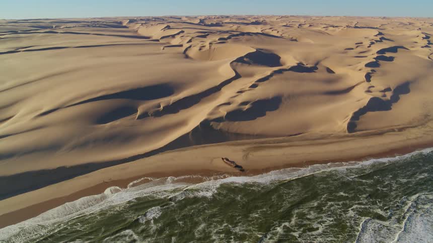 Aerial view of a shipwreck on the Skeleton Coast in Namibia where the ocean meets the desert