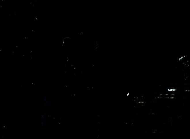 Cars are driving through a downtown city at night