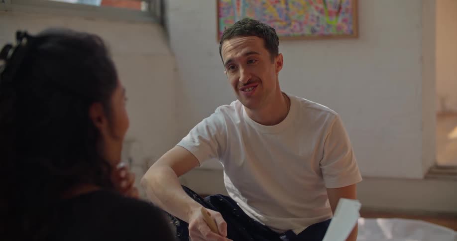 Man and woman are sitting indoors with paint brushes