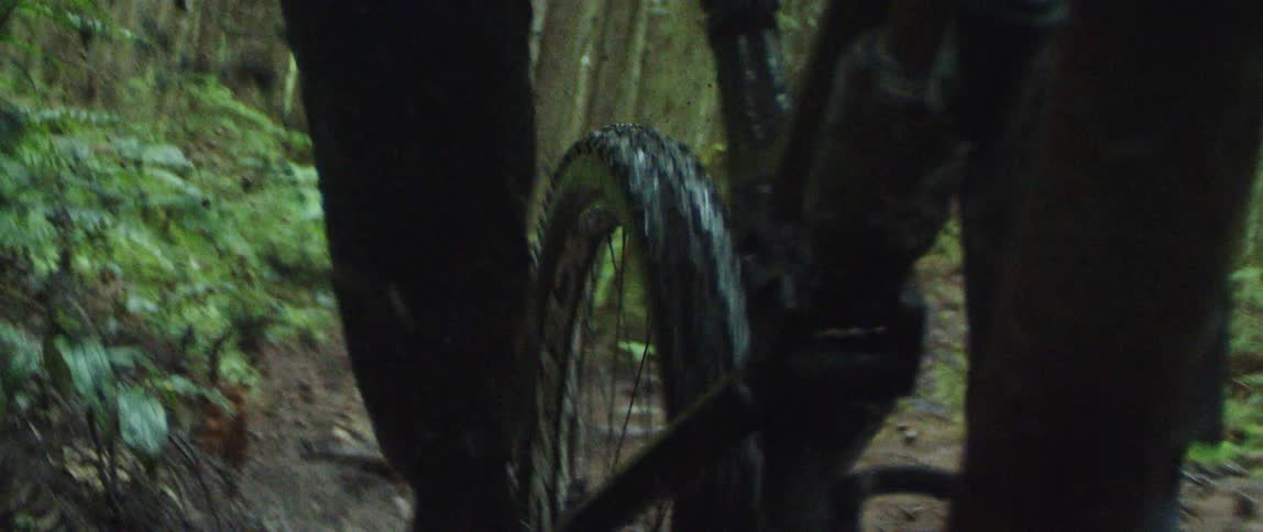 Point of view perspective of mountain bike splashing through mud puddle