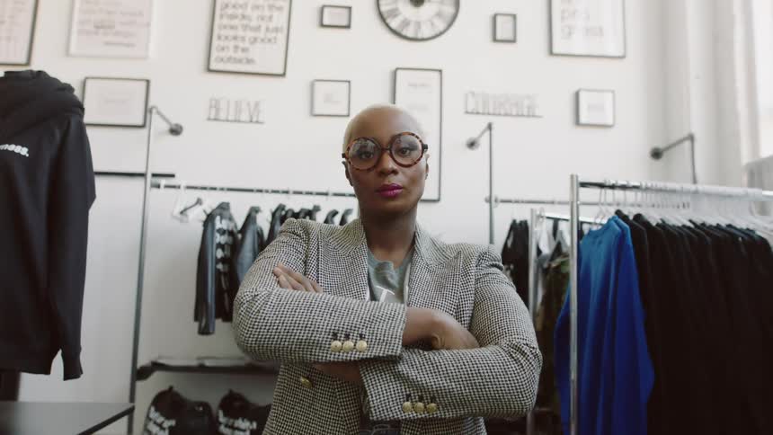 Business woman is standing in front of some clothes