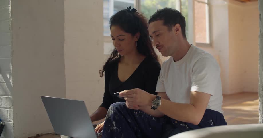 Man and woman are talking and looking at a laptop