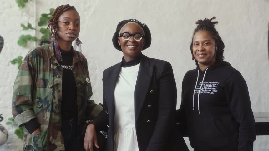 Three women are smiling at the camera