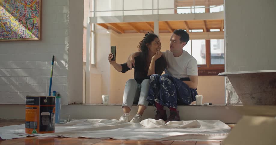 Man and woman are sitting on the floor and talking on the phone